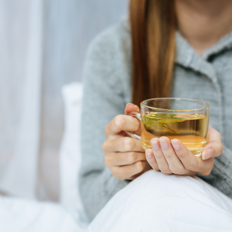 Eine Person genießt einen gesunden Tee mit Ayurvedischen Superkräutern.