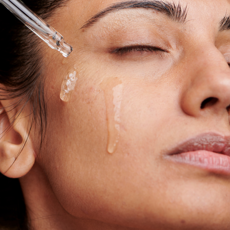 Woman applying serum to skin